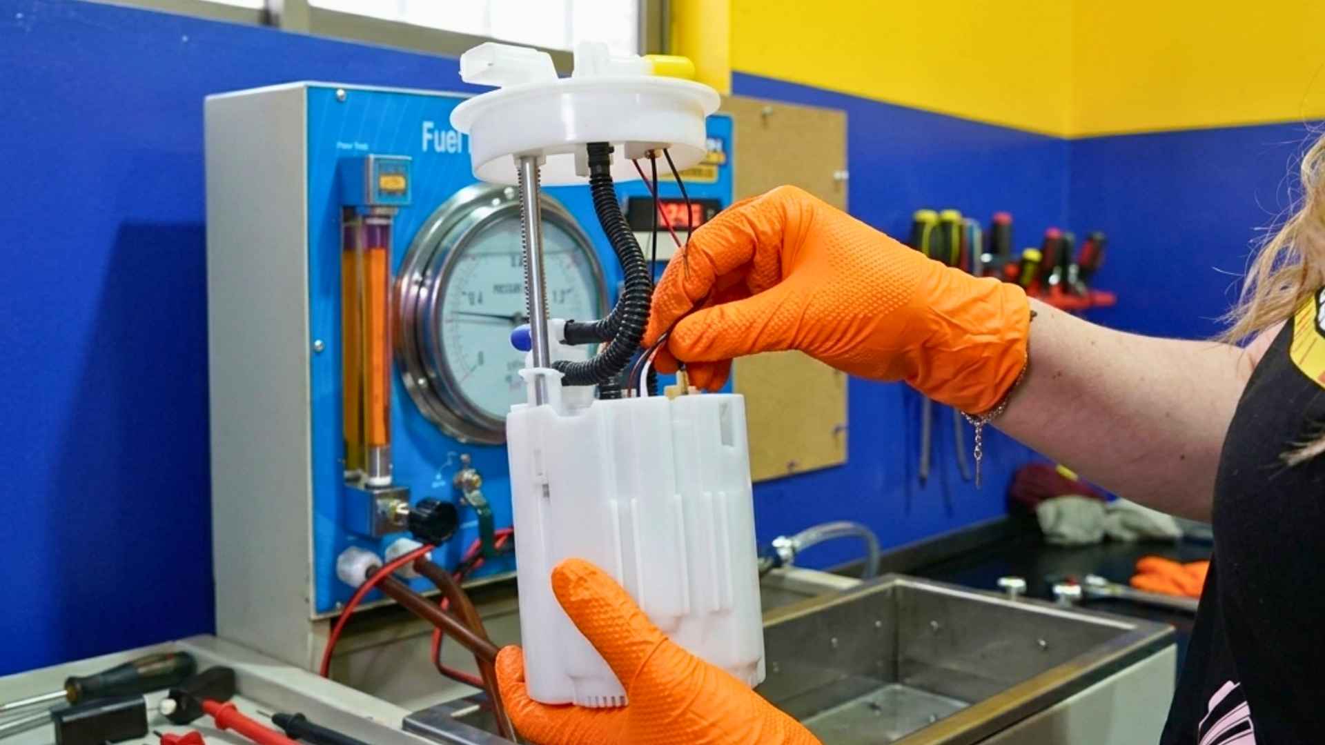 Mecánico revisando bomba de bencina e inyectores en sistema de combustible de vehículo en taller especializado en Chile